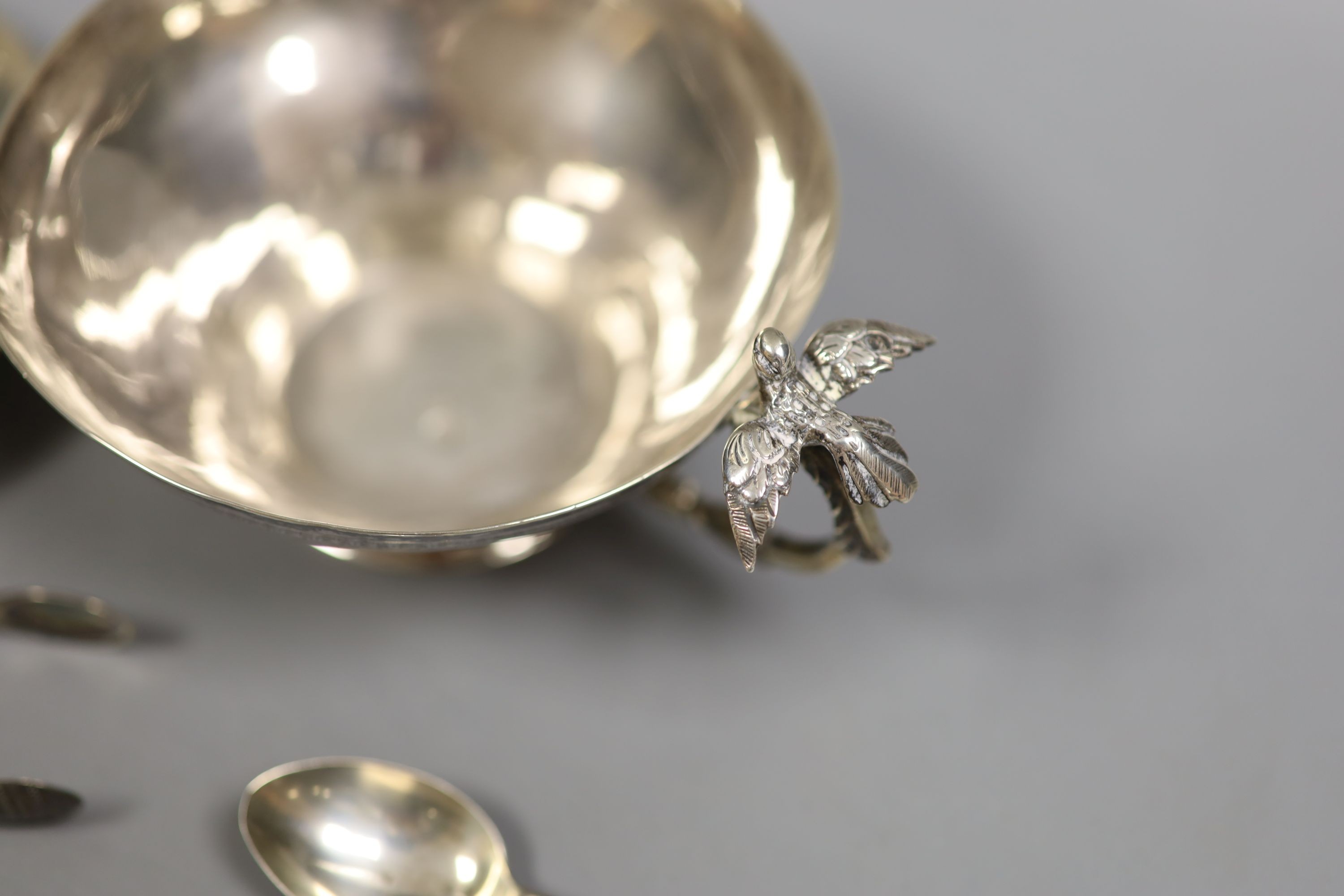 A Persian white metal tea cup and saucer and small sile items including two pepperettes, a trinket box and assorted minor flatware